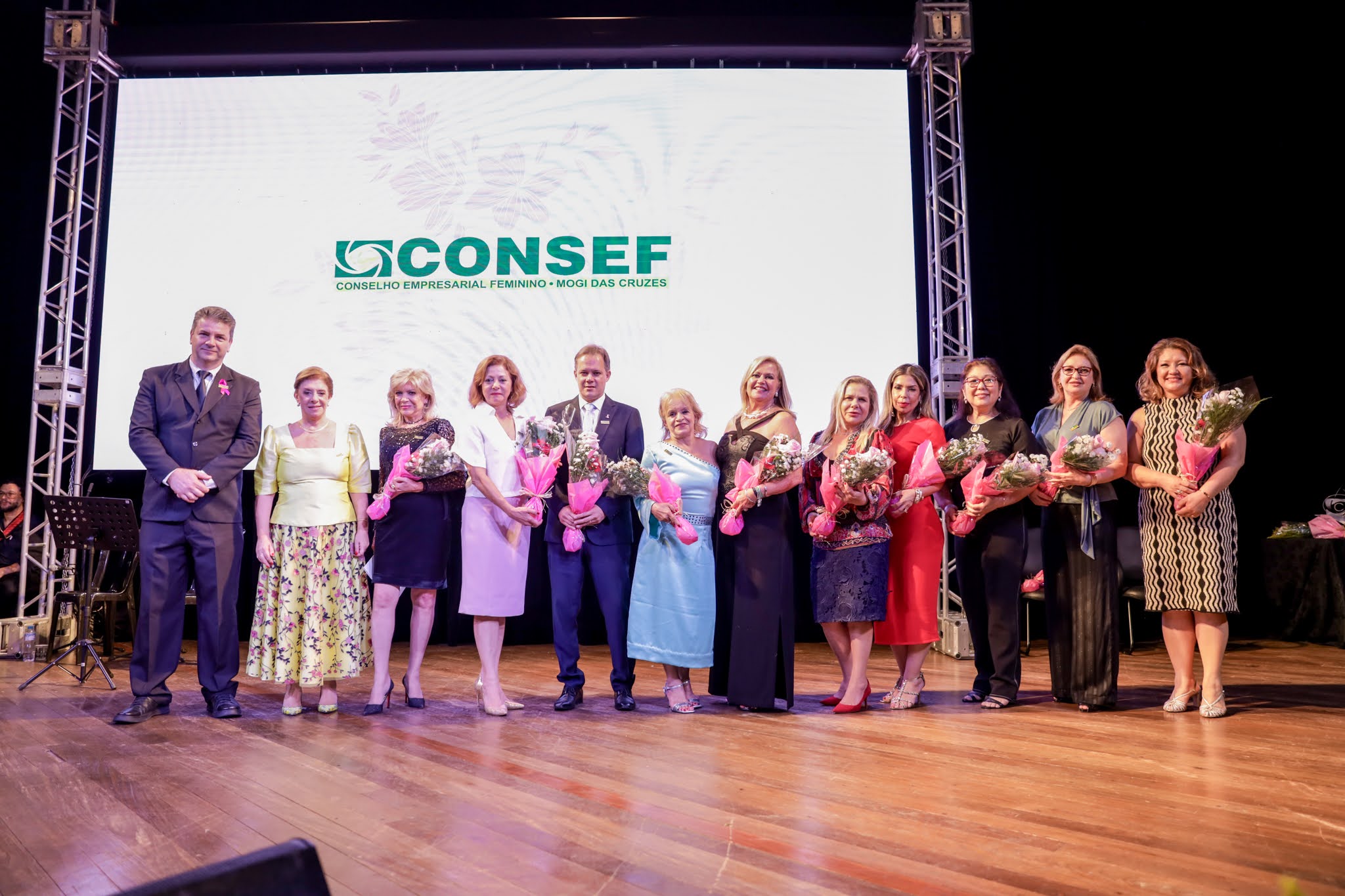 Grupo de homenageadas reunidas no palco