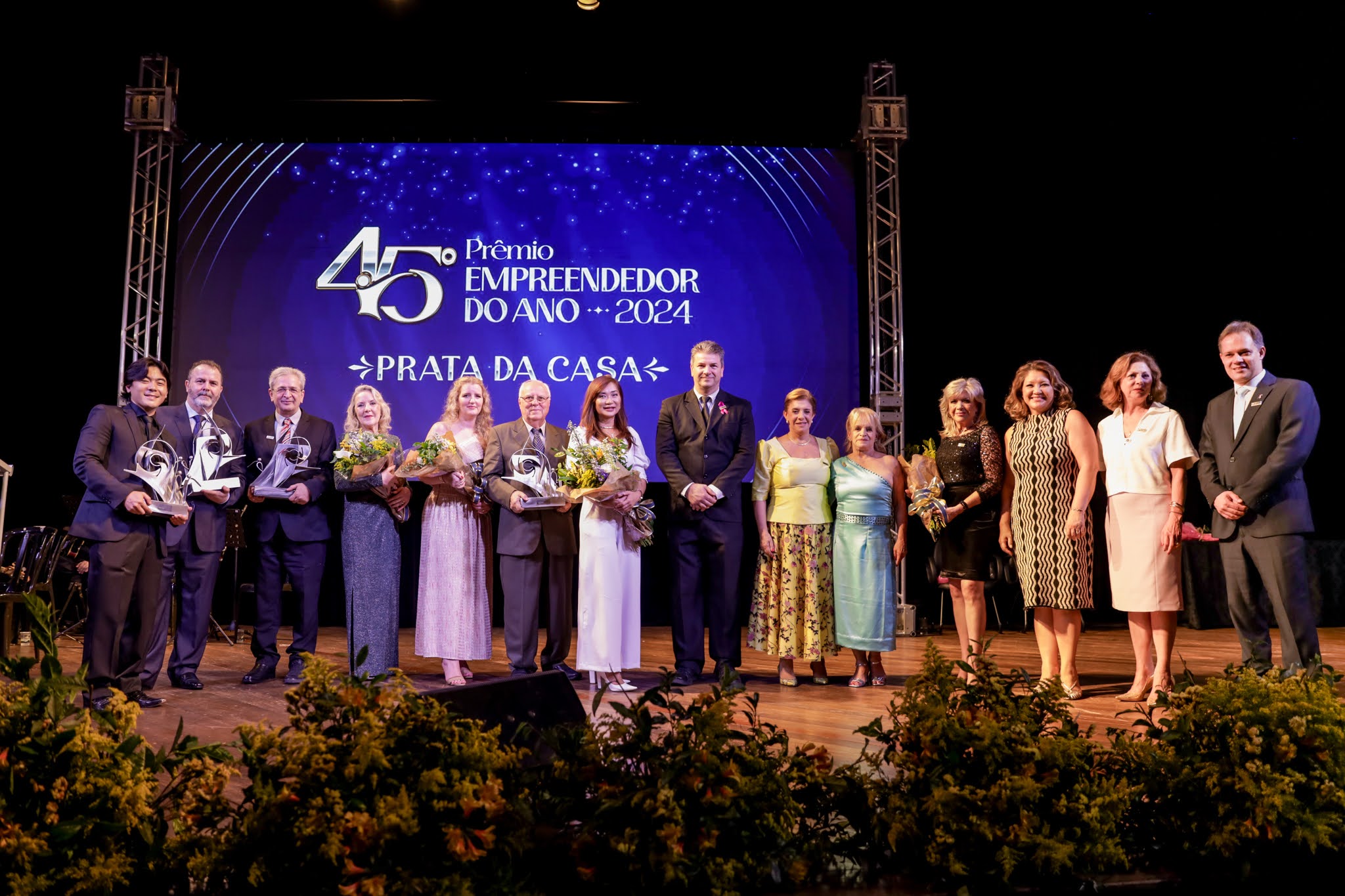 Premiados e convidados reunidos no palco em 2024